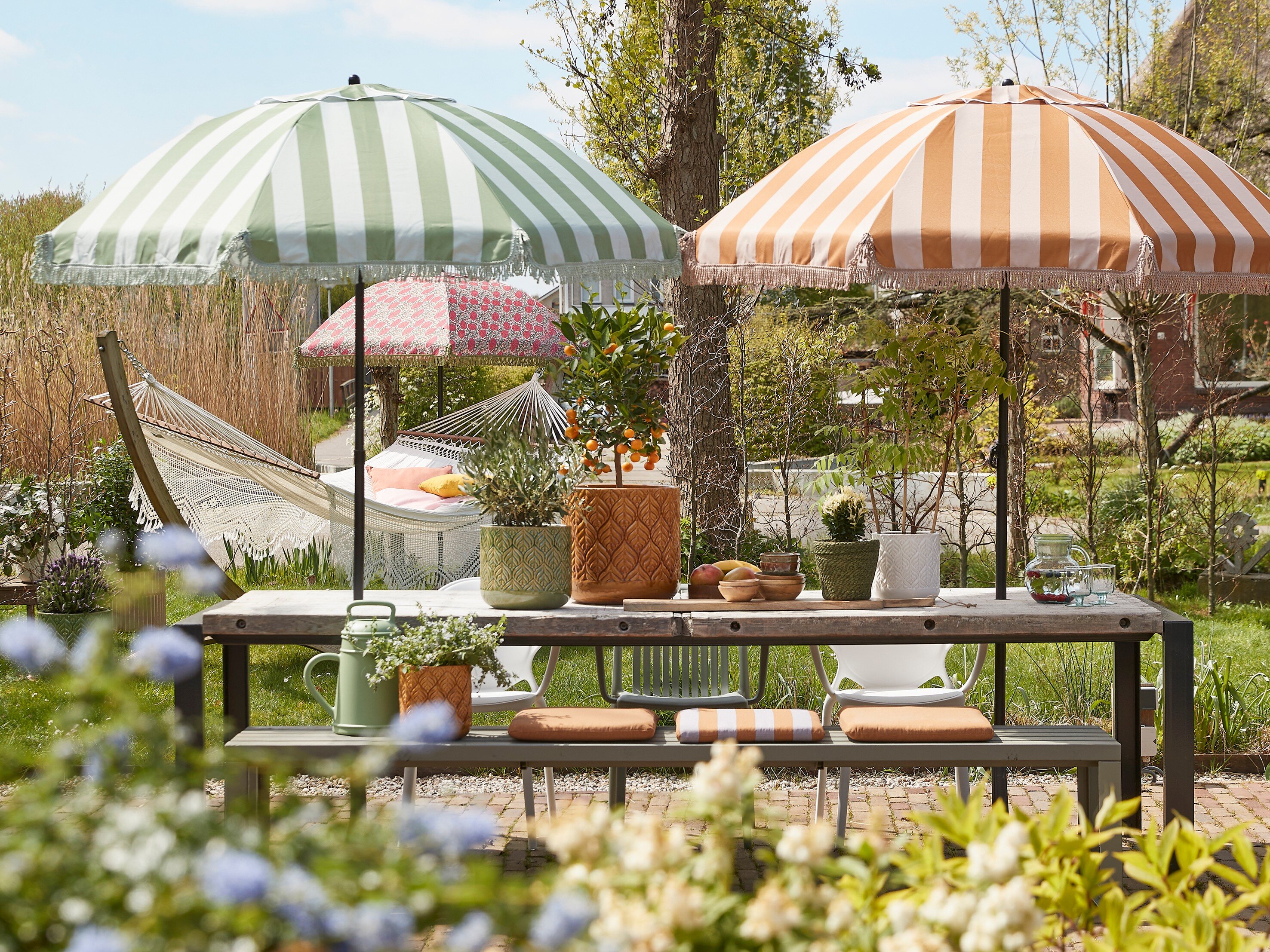 Tilting Parasols from Mica Decorations Spread across a Large Back Garden.